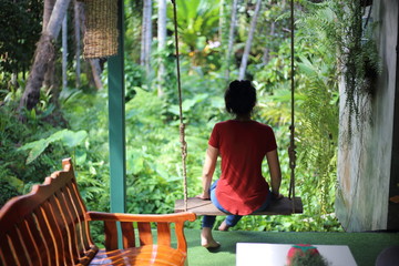 Woman sitting in garden with green plants	