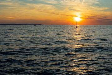 Bright sunset with large yellow sun and orange clouds