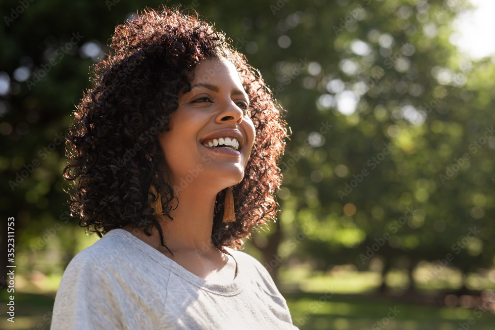 Smiling young woman enjoying a sunny day in the park Stock Photo ...