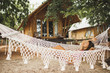 Woman relaxing in the white handmade macrame hammock on tropical beach. Travel, leisure and vacations concept.