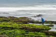 Long exposure photograph of a shellfisherman working on the rocks at Seixo beach, Torres Vedras