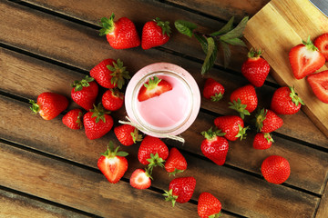 Wall Mural - Glass of fresh strawberry yogurt and fresh strawberries on table. Healthy food and drink concept with juicy fresh fruits and dairy dessert