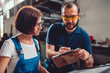 © kerkezz - Factory supervisor checking work order for female manual worker