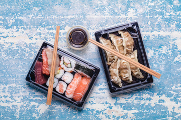 Sushi to go concept. Takeaway box with assorted sushi and gyoza