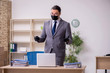 © Elnur - Young male employee in the office during pandemic disease