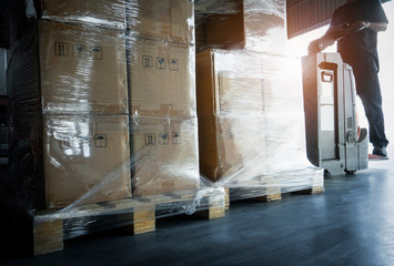 Wall Mural - Warehouse worker driving electric forklift pallet jack unloading shipment pallet goods. Package boxes, Warehouse shipping cargo service.