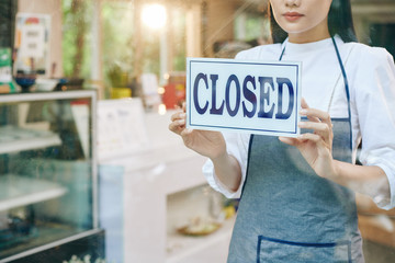 Poster - Sad female restaurant owner closing door and hanging sign