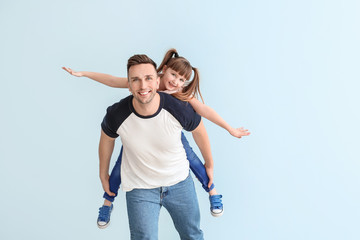 Wall Mural - Happy man with little adopted girl on color background