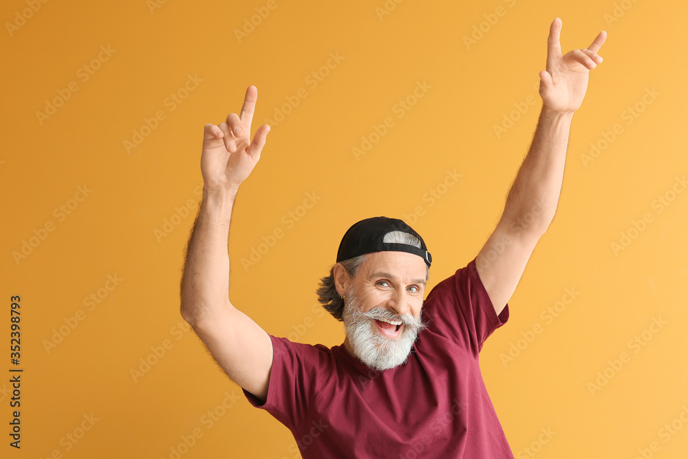 Cool senior man dancing against color background