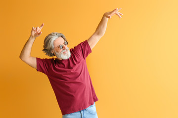 Wall Mural - Cool senior man dancing against color background