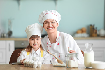 Poster - Female chef and her little daughter cooking in kitchen