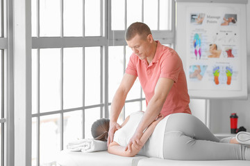 Poster - Massage therapist working with female patient in medical center