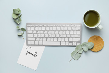 Computer keyboard with tea on light background