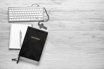 Holy Bible, notebook and PC keyboard on wooden background