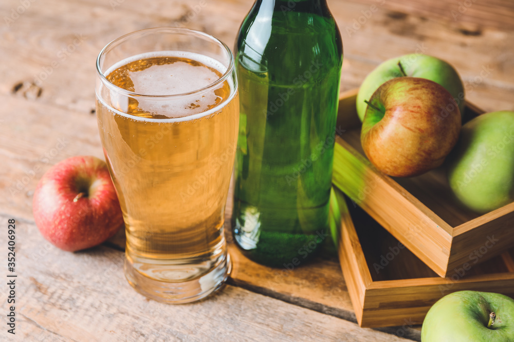 Bottle and glass of apple cider on table - obrazy, fototapety, plakaty 