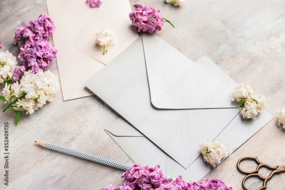 Composition with beautiful lilac flowers and envelopes on light background - obrazy, fototapety, plakaty 
