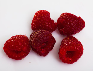 Image  of ripe red fresh  raspberries on white surface