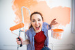 © satura_ - Funny female painting the wall with paint roller. Portrait of a young beautiful woman painting wall in her new apartment. Redecoration and renovation concept.