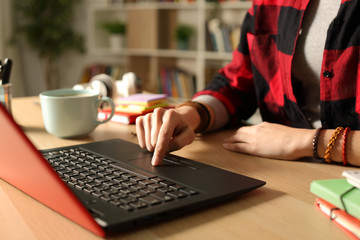 Student girl hand using laptop in the night at home