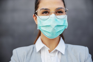 Portrait of gorgeous businesswoman with protection mask on standing outdoors. Protection form corona virus concept.