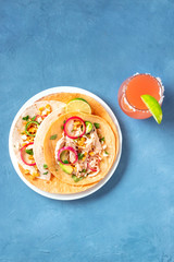 Wall Mural - Mexican tacos, tortillas with pulled chicken meat, avocado, corn, and onion, with the Paloma cocktail, overhead shot with copyspace