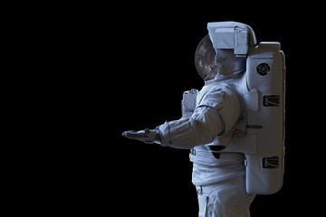 Wall Mural - astronaut presenting an empty space isolated on black background 