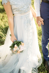 Wall Mural - Wedding photo, wife and husband walking outdoor at sunset 