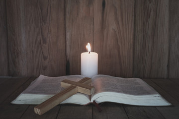 The crucifix rested on the Bible. While there are candles that illuminate Christian religious concepts, the crucifixion of faith and faith in God. Bible study.