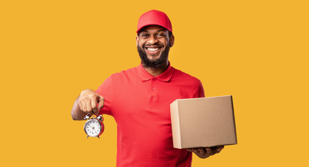 Wall Mural - Courier Holding Clock And Box Standing Over Yellow Background, Panorama