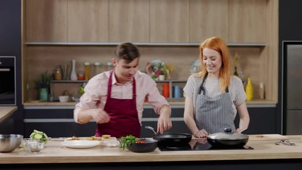 Wall Mural - Cooking show hosts chefs, male and female, cooking meat. Morning TV cooking programme. Shot on ARRI Alexa Mini