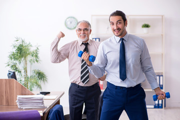 Two employees doing physical exercises at workplace