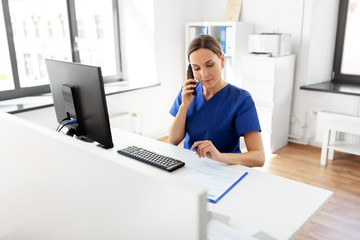 Wall Mural - medicine, technology and healthcare concept - female doctor or nurse with computer and clipboard calling on phone at hospital