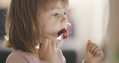cute little girl eating strawberries