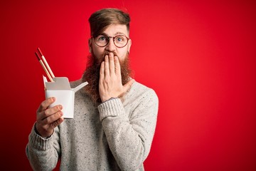 Sticker - Redhead Irish man with beard holding box of ramen eating asian food using chopsticks cover mouth with hand shocked with shame for mistake, expression of fear, scared in silence, secret concept