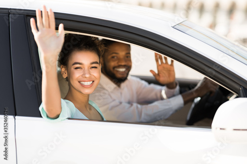 Happy African American Couple Waving Good Bye Sitting In Auto