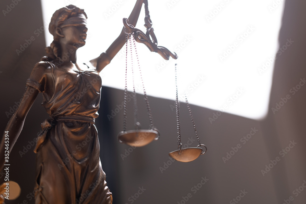 Scales of Justice, Justitia, Lady Justice and Law books in the background.. - obrazy, fototapety, plakaty 
