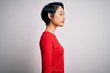 © Krakenimages.com - Young beautiful asian girl wearing casual red t-shirt standing over isolated white background looking to side, relax profile pose with natural face and confident smile.