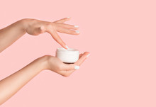 Unrecognizable Girl Applying Cream From Jar Onto Her Hands Against Pink Background, Blank Space