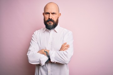 Wall Mural - handsome bald man with beard wearing elegant shirt over isolated pink background skeptic and nervous