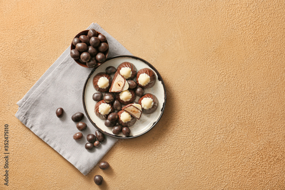 Tasty chocolate candies on color background