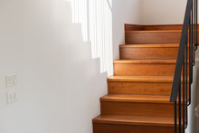 Light And Shadow On Wooden Stair Steps With Black Steel Handrail. House Interior Concept.