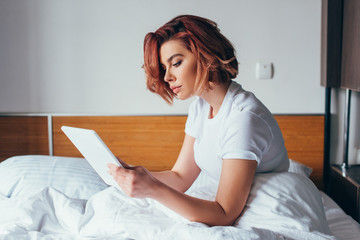 Wall Mural - beautiful young woman using digital tablet in bed on quarantine