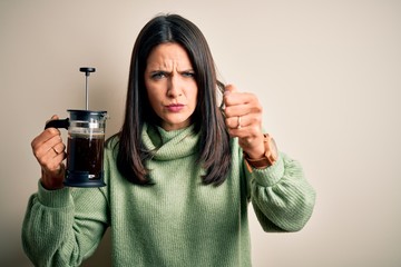 Sticker - Young woman with blue eyes making cafe using coffe maker standing over white background annoyed and frustrated shouting with anger, crazy and yelling with raised hand, anger concept