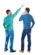 © ghoststone - Back view of two man in sweater pointing.