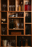 Fototapeta Panele - Bottles of wine and glasses in cellar