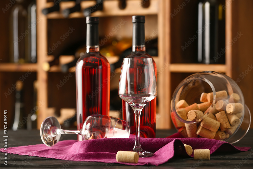 Bottles of wine and glasses on table in cellar