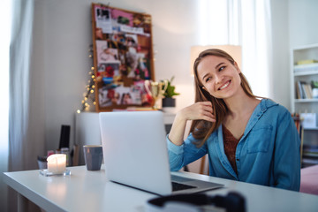 Wall Mural - Beautiful happy young girl with laptop sitting and smiling, online dating concept.