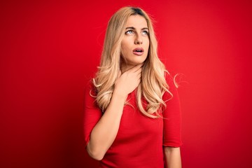 Canvas Print - Young beautiful blonde woman wearing casual t-shirt standing over isolated red background Touching painful neck, sore throat for flu, clod and infection