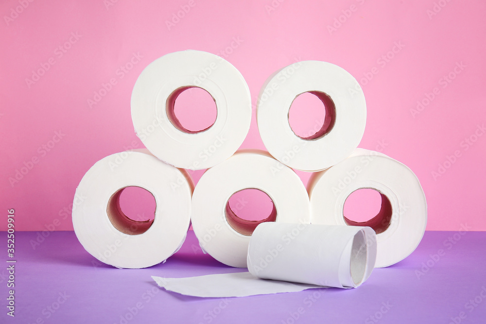 Rolls of toilet paper on color background