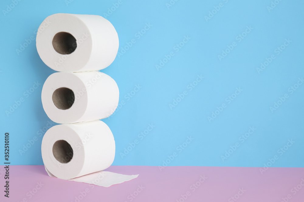 Rolls of toilet paper on color background